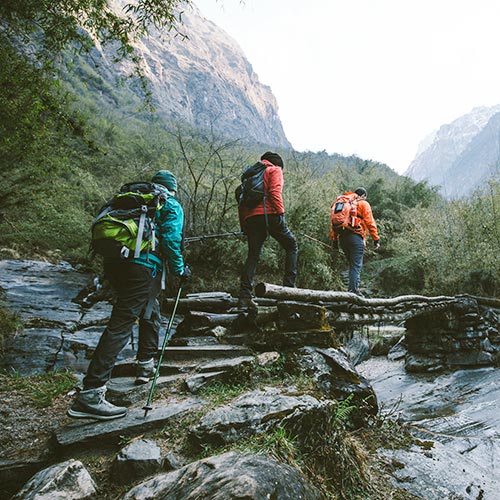 Three hikers near a rocky stream